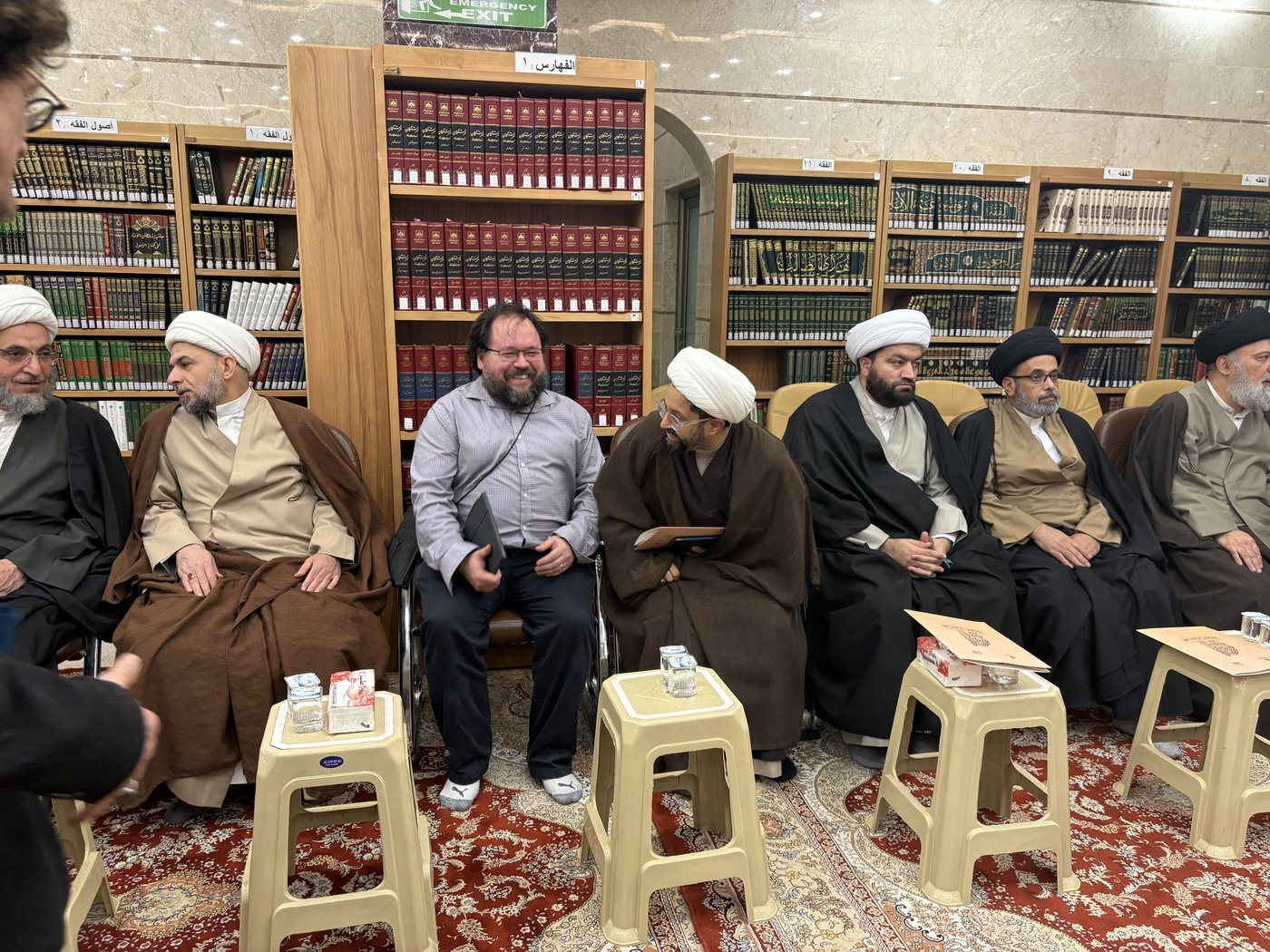 Dr. Hewko seated among Najaf scholars in the hawza library.