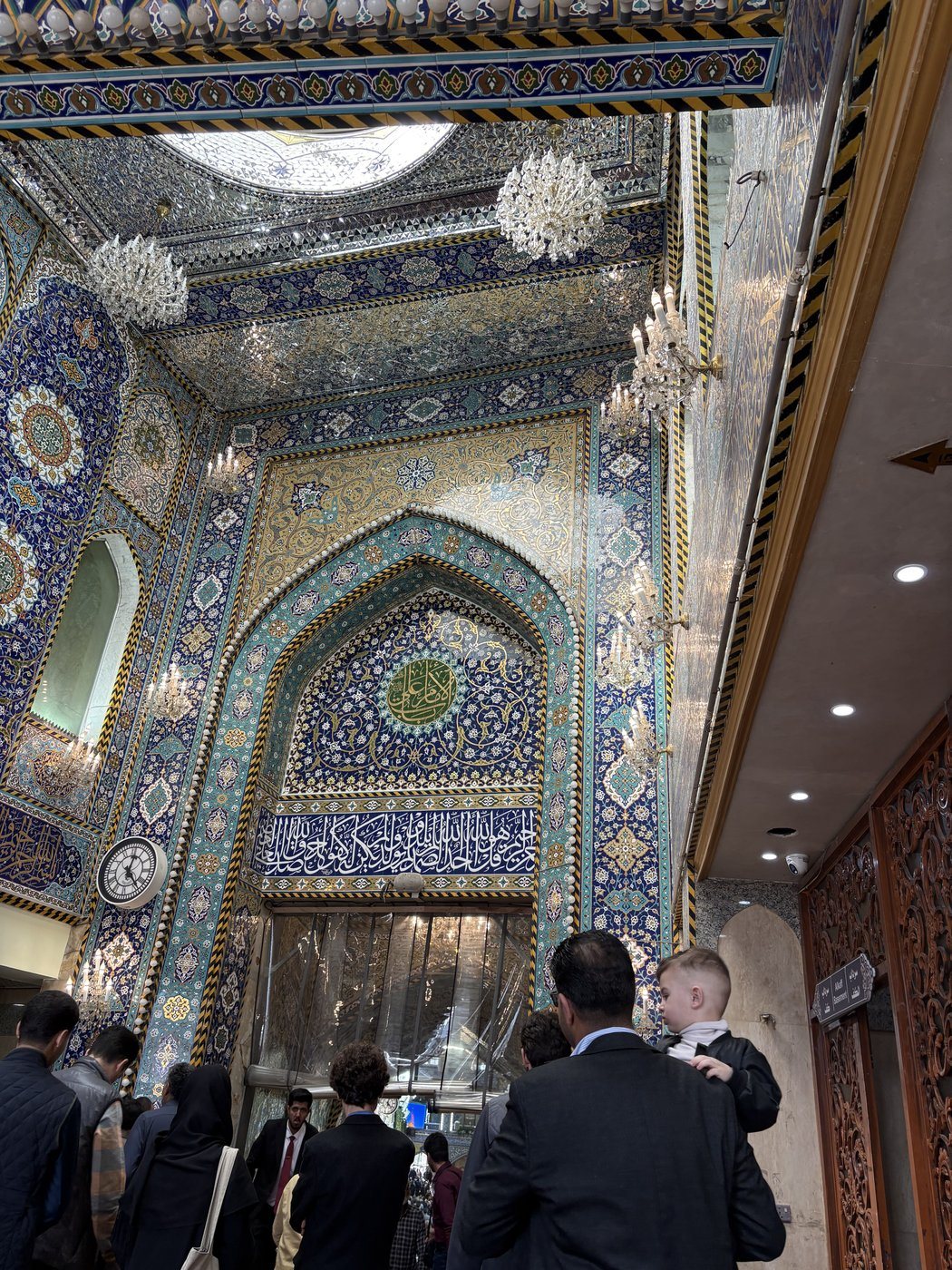 Entering the shrine beneath a mirror-mosaic portal, Karbala.