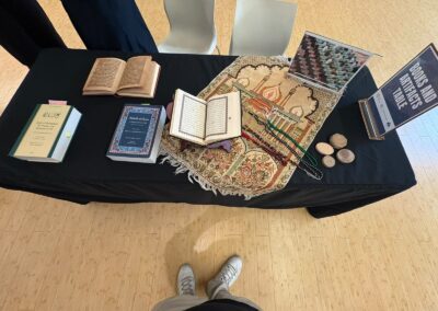 Overhead view of the Books and Artifacts Table with a Qur'an, prayer beads, prayer stones and books