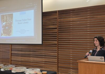 Presenter speaking beside a Thomas Fisher Rare Book Library slide
