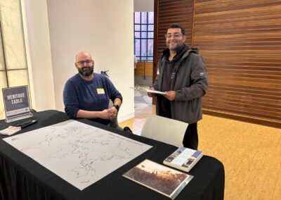Hosts at the Heritage Table with its "Where are you connected to?" world map