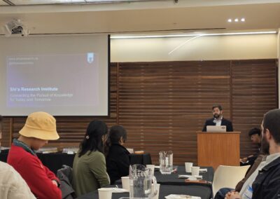 Speaker at the podium presenting the Shi'a Research Institute to students