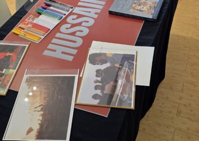 The Story Table set with books, framed photographs and a Hussain display