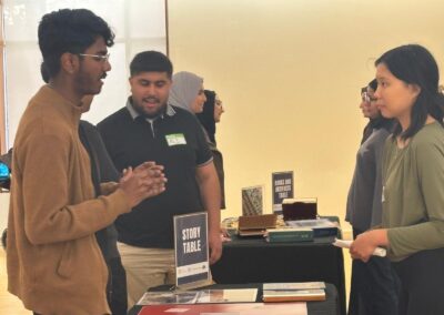 Students in conversation at the Story Table, with the Books and Artifacts Table behind